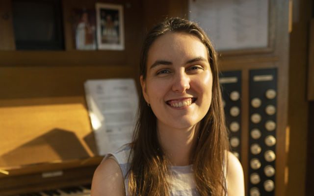 A woman sat in front of an organ.