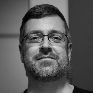 A man with short hair and glasses.
