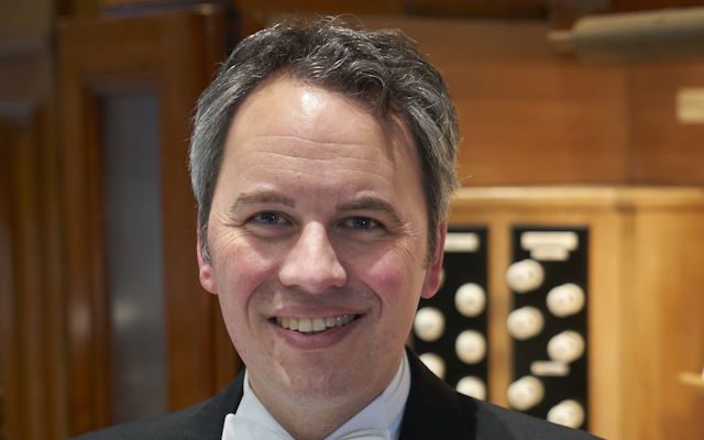 A man sat in front of an organ.