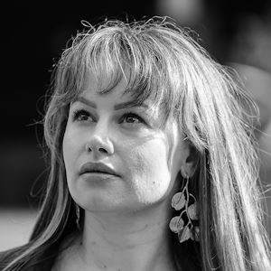 A woman wearing earrings looking up.