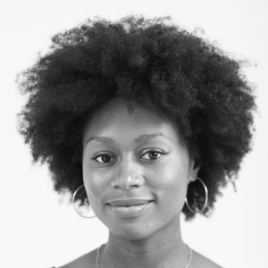 A woman wearing hoop earrings looking into the camera.