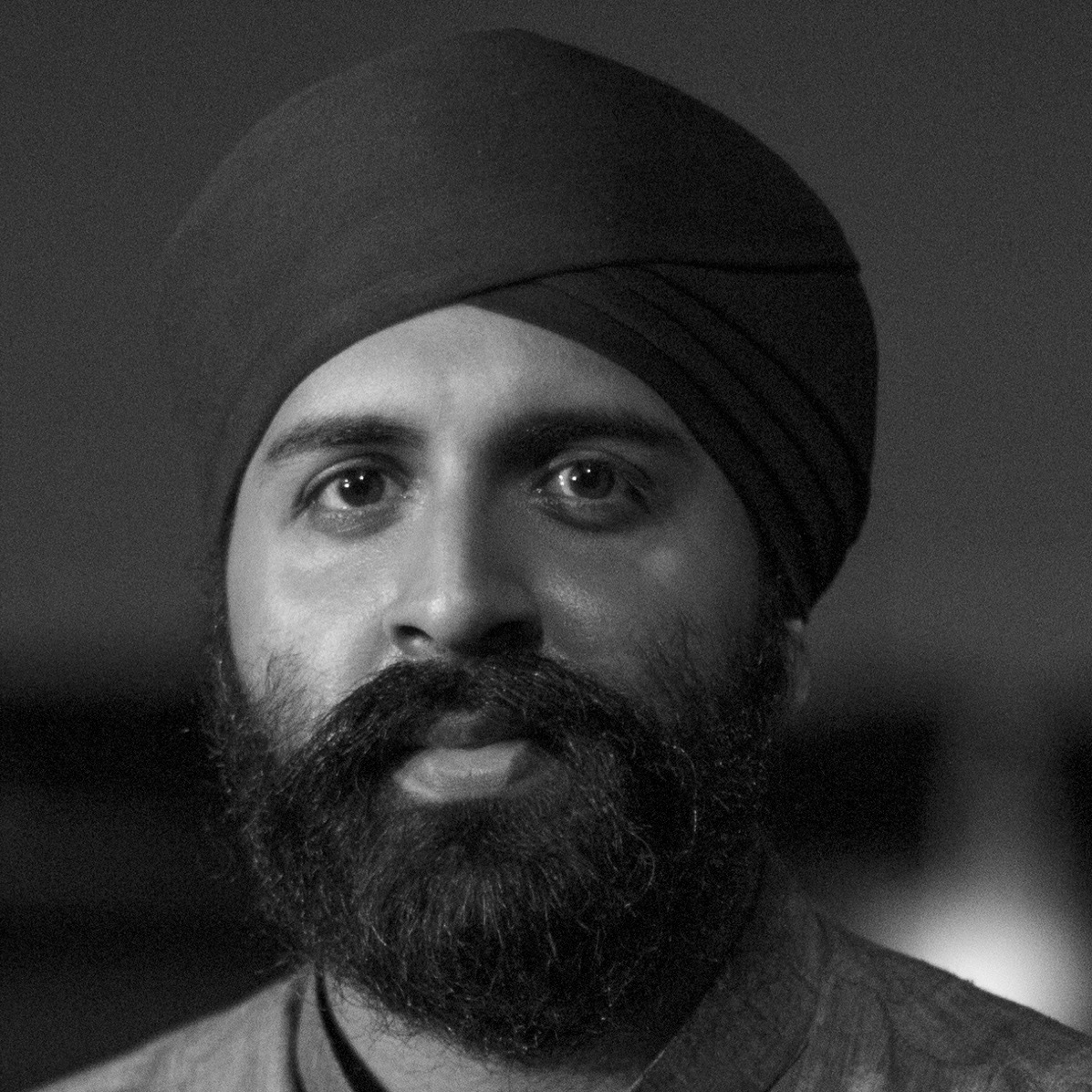 A man with a beard and wearing a black turban.