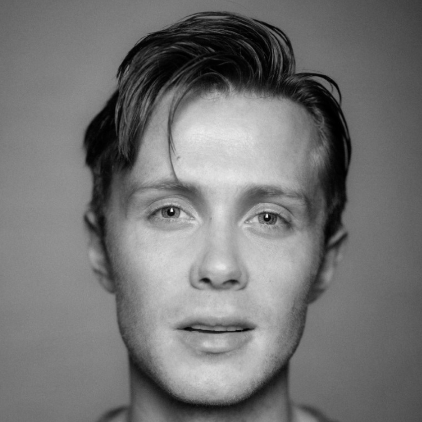 A man with short hair wearing a sweater.